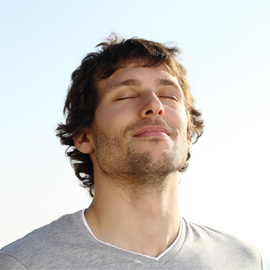 Man closing his eyes and breathing the air