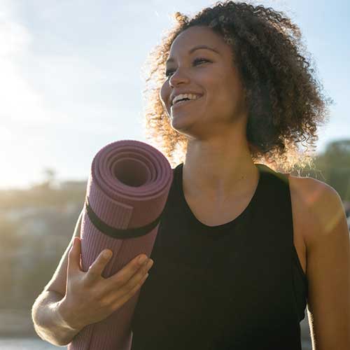 Woman holding yoga mat